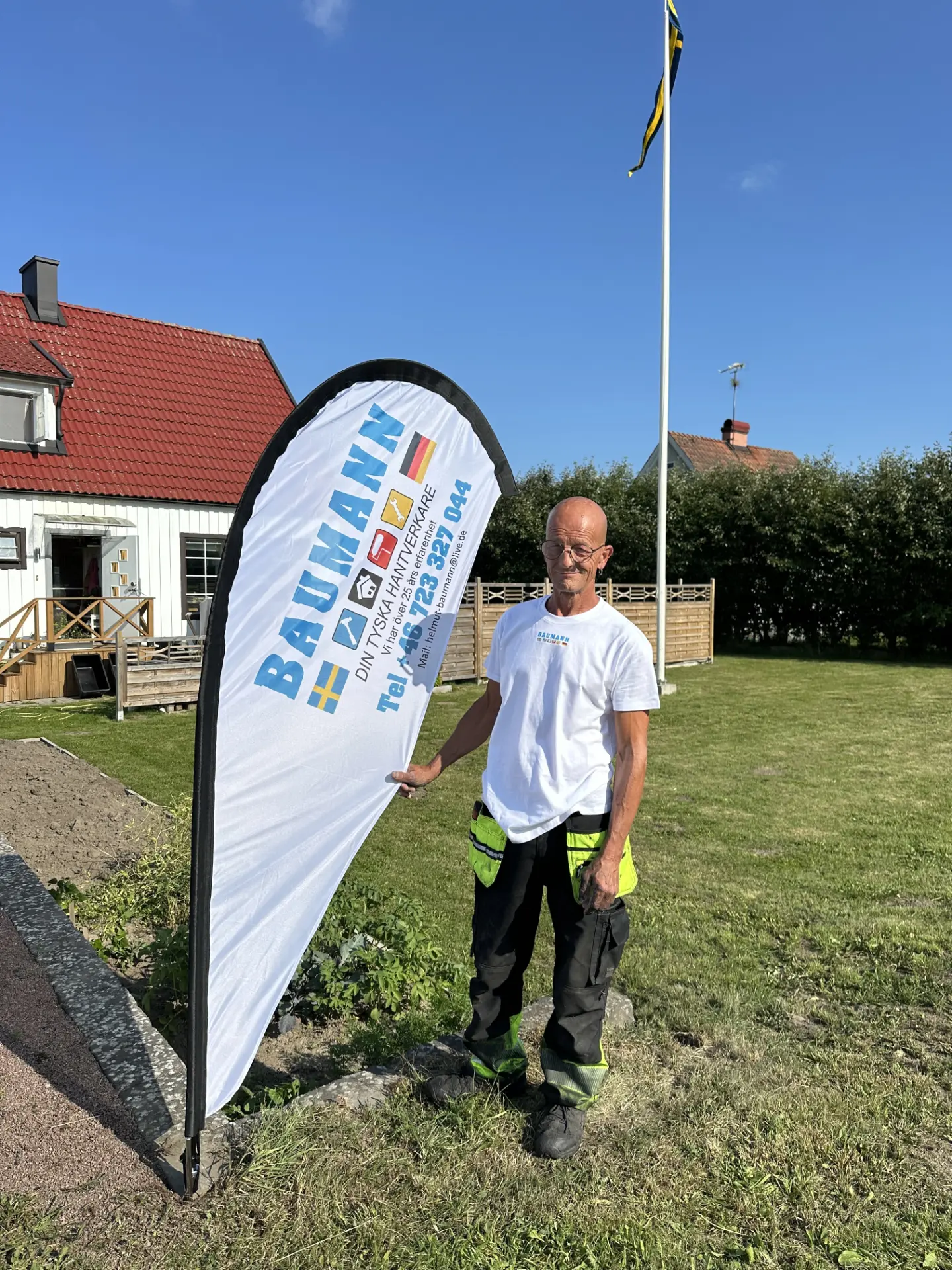 Ingo, grundare av Baumann Bygg, vid företagets flagga